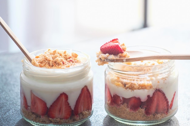 Twee potjes aardbeienpudding magnoliawoestijn op een rustieke achtergrond met omgekeerde verlichting