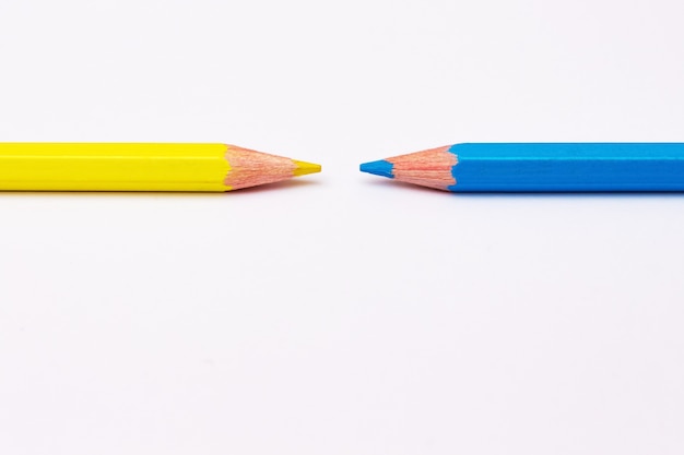 Twee potloden van geel en blauw symboliseren het tegenovergestelde