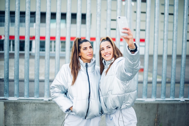 Foto twee prachtige tweelingzusjes met behulp van smartphone