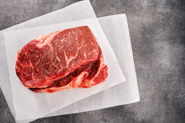 Twee Raw New York strip steak op wit papier, bovenaanzicht.