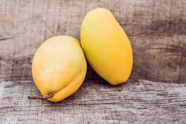 Twee rijpe mango's op een houten ondergrond