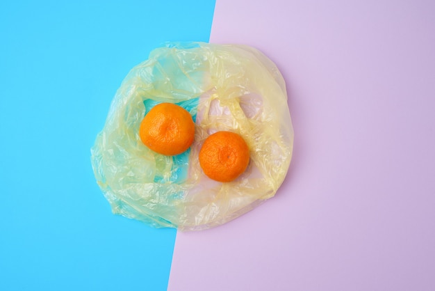 Twee rijpe oranje mandarijnen in een plastic zak