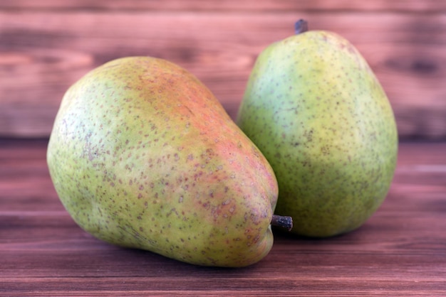 Twee rijpe peren op een oude houten tafel.