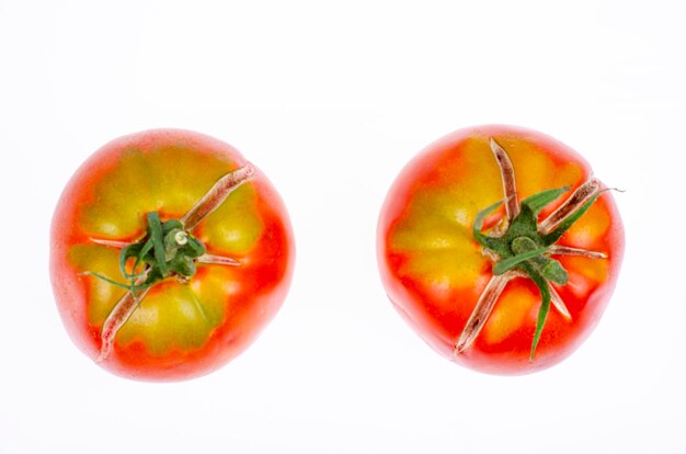 Twee rijpe rode tomaten met gebarsten huid. Studiofoto.