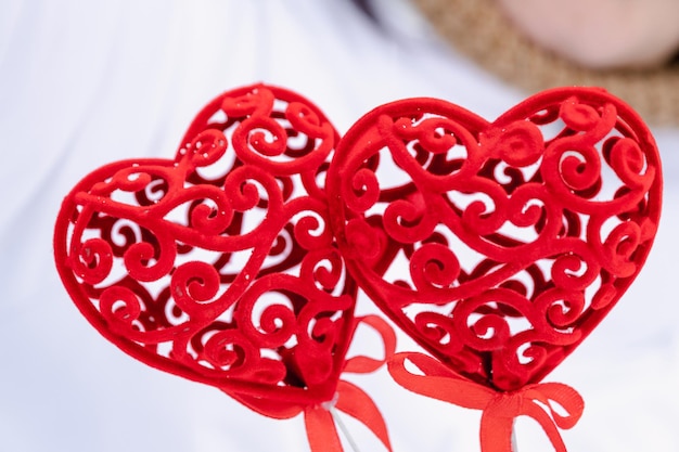 Twee rode harten in de handen - een wenskaart voor Valentijnsdag, de feestdag van alle geliefden op 14 februari. Kopieer de ruimte. Uitnodiging voor een date, liefde, dating, valentijnskaart