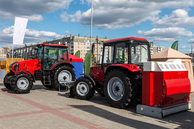 Twee rode tractoren op wielen op een landbouwbeurs