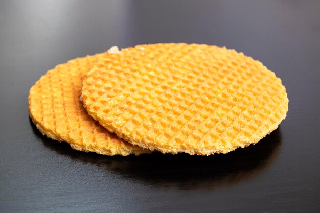 Twee ronde wafels op een zwarte houten tafel