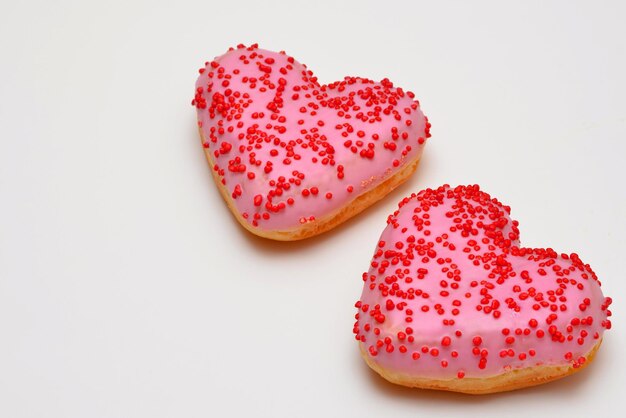 Foto twee roze donuts harten op een witte achtergrond dichtbij