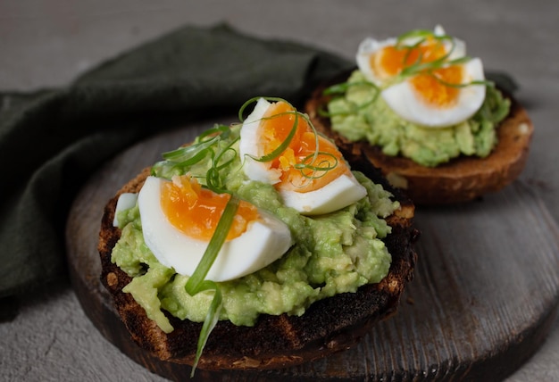 Twee sandwiches op geroosterd brood met selectieve aandacht voor avocado en ei