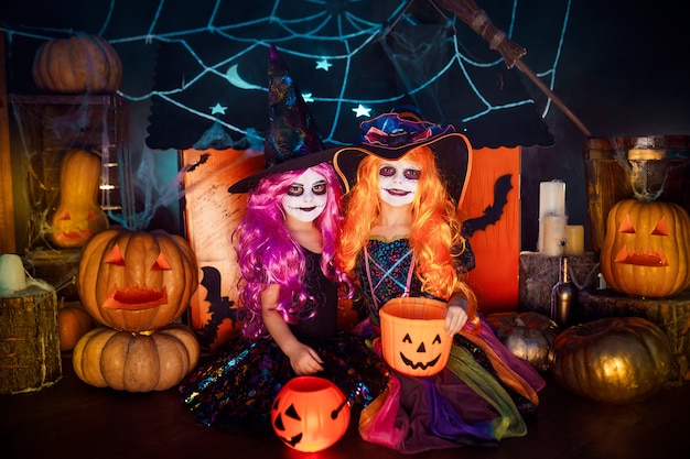 Twee schattige grappige zussen vieren de vakantie. Heel kinderen in Carnaval-kostuums klaar voor Halloween.