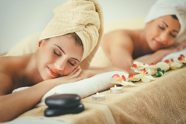 Twee schattige jonge vrouwen genieten tijdens een huidverzorgingsbehandeling in een spa.