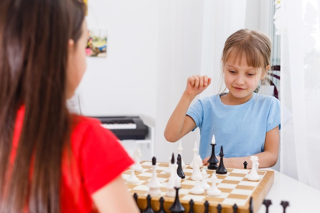 Twee schattige kinderen die thuis schaken