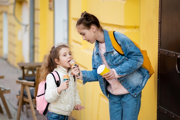 Twee schattige zustermeisjes eten ijs buiten Takeaway Childhood Het concept van heerlijk eten