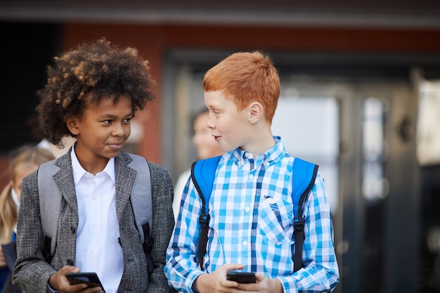 Twee schooljongens met mobiele telefoons