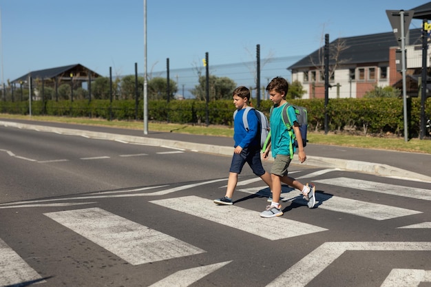 Twee schooljongens steken de weg over op een zebrapad