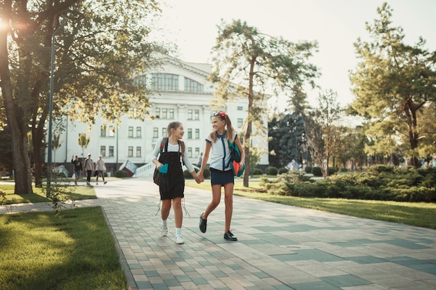 Twee schoolvrienden lopen na de lessen in een park bij de school