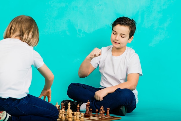 Twee serieuze jongen die schaakstudio blauwe achtergrond spelen