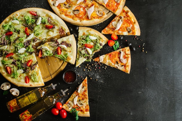 Twee soorten pizza gesneden op stukken op zwarte achtergrond