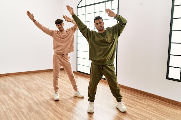 Twee spaanse mannen koppelen dansers die glimlachend zelfverzekerd dansen in het sportcentrum