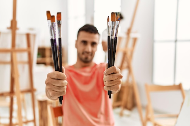 Twee Spaanse mannen koppelen glimlachend zelfverzekerd tekenen in de kunststudio