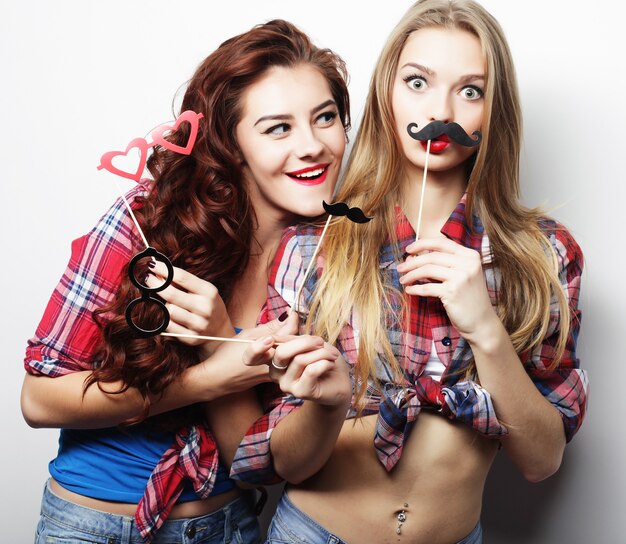 Twee stijlvolle sexy hipster meisjes beste vrienden klaar voor feest, over grijze achtergrond