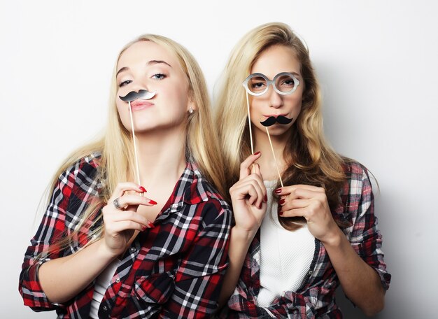 Twee stijlvolle sexy hipster meisjes beste vrienden klaar voor feest, over grijze achtergrond