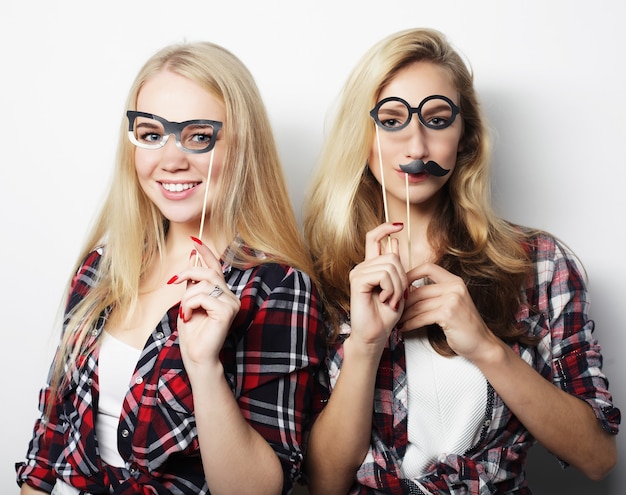 Twee stijlvolle sexy hipster meisjes beste vrienden klaar voor feest, over grijze achtergrond