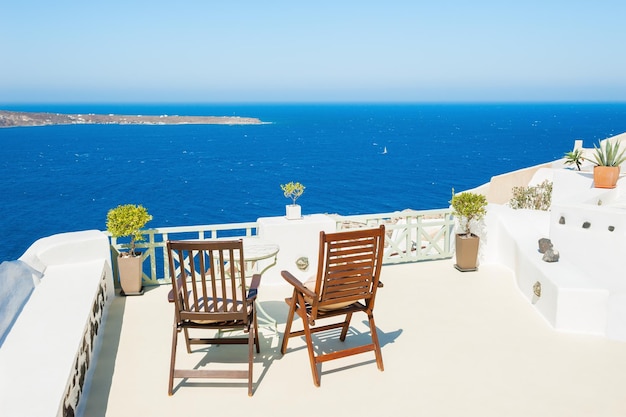 Twee stoelen op het terras met uitzicht op zee. Santorini-eiland, Griekenland.