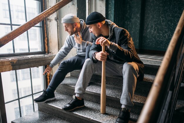 Twee straatbandieten die met honkbalknuppel op slachtoffer wachten. Crimineel, diefstalgevaar, gevaarlijke jongens