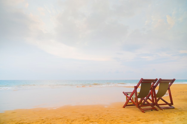 Twee strandstoelen op het strand.