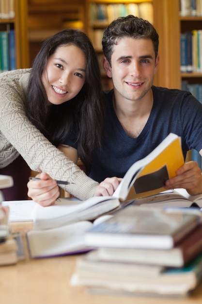 Twee studenten die aan een bureau in een bibliotheek bestuderen