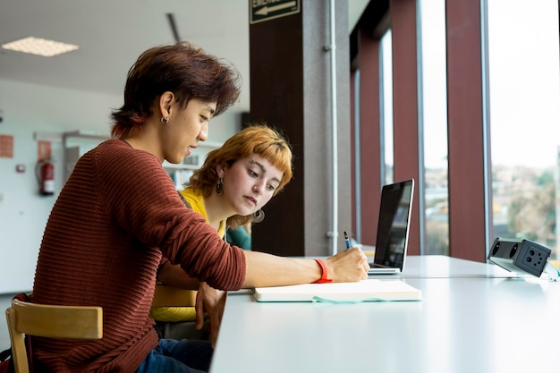 Twee studenten die samen studeren in een bibliotheek