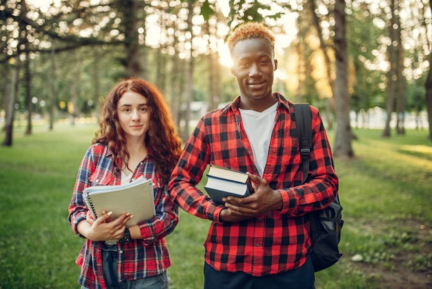 Twee studenten met boeken vormt in zomerpark.