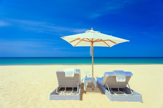 Twee sunbed en één paraplu op het strand in Phuket, Thailand