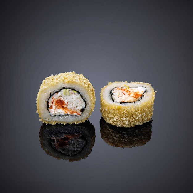 Twee sushi-broodjes staan op een zwarte achtergrond met een witte achtergrond.