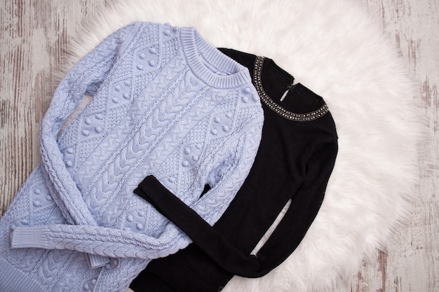 Twee sweaters op witte vacht.