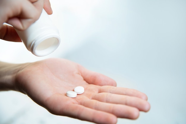 Twee tabletten in de palm van iemands hand