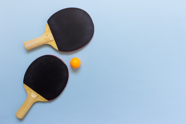 Twee tafeltennis zwarte rackets met oranje bal