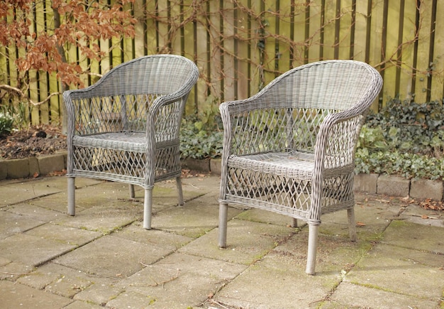 Twee terrasstoelen in een tuin of achtertuin Handgemaakt buitenmeubilair in een zithoek of binnenplaats Set cottage-fauteuils met traditionele patronen uit het midden van de eeuw of bohemien