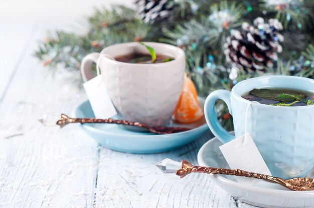 Twee theekopjes met theezakje en kerstboom