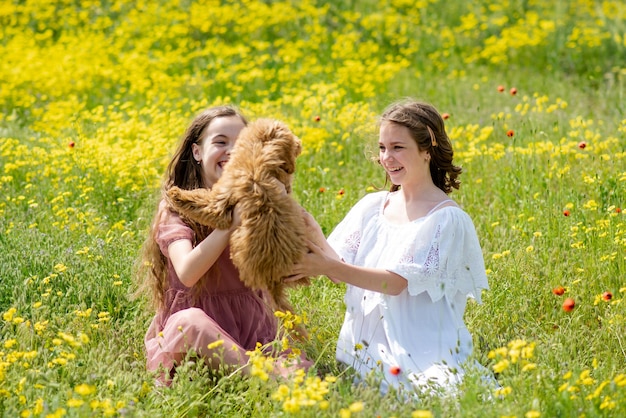 Twee tienermeisjes met een hond in de natuur communiceren en hebben plezier