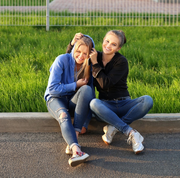 Twee tienermeisjes zitten buiten samen