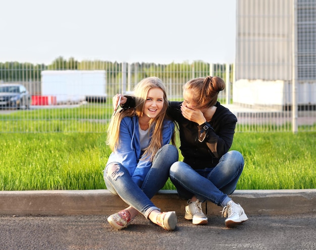 Twee tienermeisjes zitten buiten samen