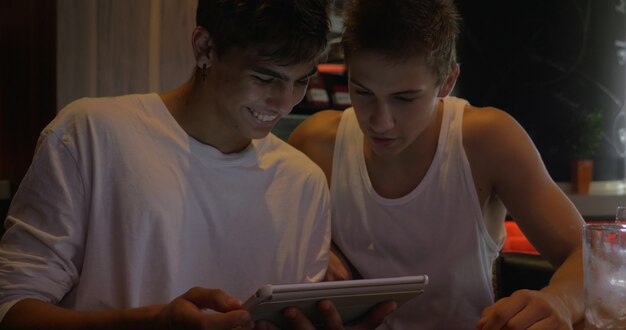 Twee tienervrienden met tabletcomputer in café