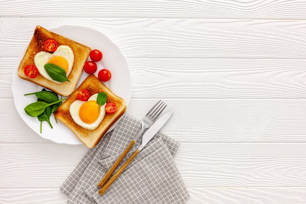 Twee toast met roerei in de vorm van een hart op een bord