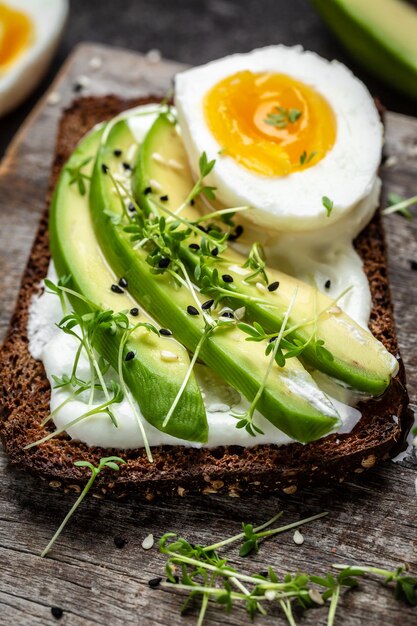 Twee toastjes met avocado gepocheerd ei en microgroen dieet of vegetarisch eten Bovenaanzicht