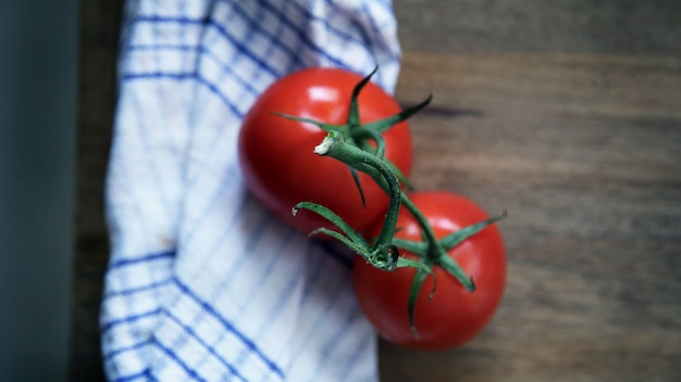 Foto twee tomaten op een tak liggen op een servet