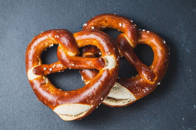 Twee traditionele zachte Oktoberfest-pretzels op zwarte achtergrond