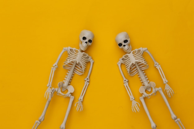 Twee valse skeletten op geel. Halloween-decoratie, eng thema