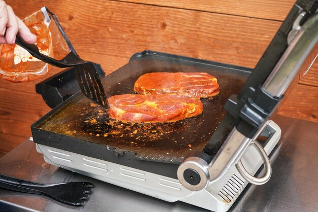 Twee varkenssteak schnitzels gegrild op elektrische grill